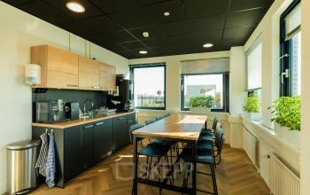 Office pantry at Prins Willem Alexanderlaan 701, Apeldoorn featuring a countertop, coffee machine, and bar-height seating, ideal for informal meetings or breaks. Ideal office space rental with natural light.