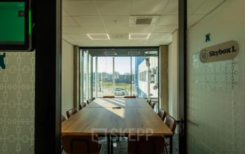 Bright office space with a large table and chairs located at Prins Willem Alexanderlaan 701, Apeldoorn, ideal for meetings or team collaborations. Perfect for office space rental.