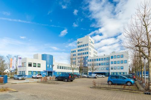 Exterior view of an office building at Prins Willem Alexanderlaan 701, Apeldoorn, showcasing a modern facade with parking facilities, ideal for office space rental.