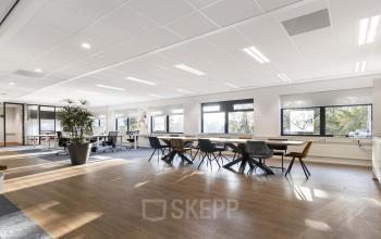 Modern office space at Waterloseweg 7a, Apeldoorn featuring an open-floor plan with ample sunlight, contemporary furniture, and large windows, ideal for office space rental.
