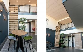 Modern interior of an office building at Waterloseweg 7a, Apeldoorn, featuring a stylish open floorplan with contemporary furnishings, wooden accents, and greenery. Ideal for office space rental, combining comfort and functionality.