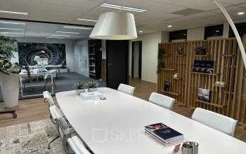 Modern office interior at Waterloseweg 7a, Apeldoorn featuring spacious workspaces with sleek white desks, ergonomic chairs, and contemporary decor. Ideal office space rental with inviting and practical arrangements for business activities.