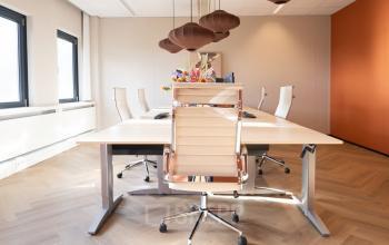 Modern furnished office space rental at Schumanpark 9, Apeldoorn with conference table and ergonomic chairs ready for business meetings.