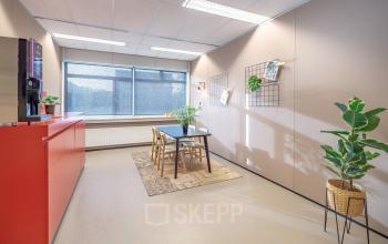 Bright office space with a table, chairs, and a coffee machine at Oude Apeldoornseweg 41-45 in Apeldoorn, available for office space rental.