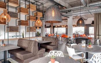 Modern office space rental at Oude Apeldoornseweg 41-45 with stylish seating, wooden accents, and a cozy atmosphere.