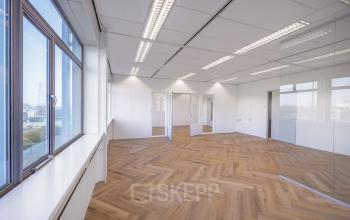 Spacious, well-lit office with herringbone flooring and large windows, available for office space rental on Oude Apeldoornseweg 41-45, Apeldoorn.