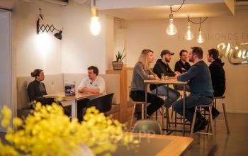 Interior of office at Roggestraat 111, Apeldoorn featuring a group of people collaborating and having discussions in a furnished lounge area.
