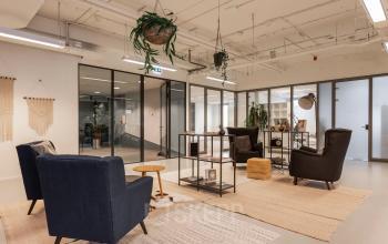 Comfortable office space at Roggestraat 111, Apeldoorn, featuring modern seating and decorative plants, available for rent.