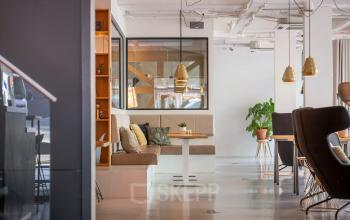 Bright and modern furnished office space on Roggestraat 111, featuring cozy seating areas and stylish decor, perfect for office space rental.