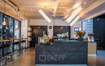 Modern office space rental at Roggestraat 111, Apeldoorn featuring a sleek furnished lounge with a bar counter and seating area.