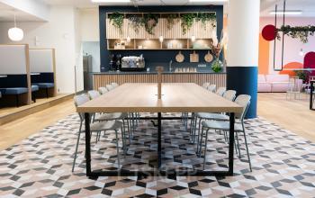 Modernly styled office space rental at Jansbuitensingel 30, Arnhem Centrum, with a large meeting table and a chic pantry area.