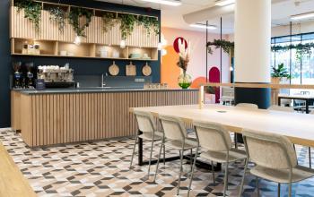 Stylish office space rental at Jansbuitensingel 30, Arnhem Centrum with a modern kitchenette and chic communal tables.