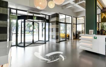Modern office entrance at Jansbuitensingel 7, Arnhem Centrum, featuring a revolving door and sleek interior design, perfect for office space rental.
