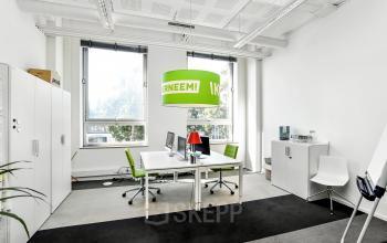 Bright furnished workspace at Jansbuitensingel 7, Arnhem Centrum, ideal for office space rental with modern desks, chairs, and large windows.