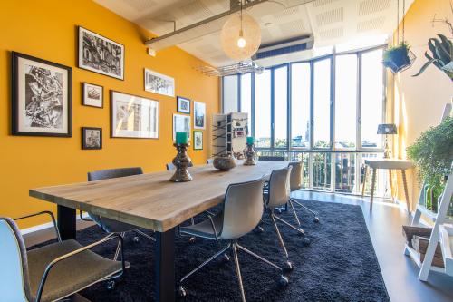 Bright office to rent at Jansbuitensingel 7, Arnhem Centrum, featuring a furnished meeting area with large windows and vibrant decor.