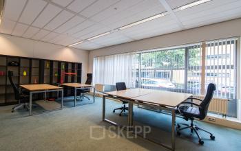 Contemporary office space rental at Meander 251, Arnhem IJsseloord with well-equipped desks and a bookshelf, offering a bright and professional environment.