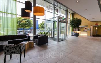Spacious and well-lit reception area at Meander 251 office space rental in Arnhem IJsseloord, with comfortable seating and modern decor.