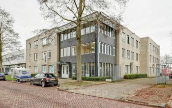 Exterior view of the office building at Bruningweg 23, Arnhem IJsseloord, featuring a modern facade and available parking spaces. Ideal for office space rental in a convenient, professional location.
