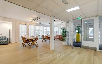 Modern office interior at Bruningweg 23, Arnhem IJsseloord featuring a spacious open floor plan with wooden floors, natural light, and stylish furnishings ideal for office space rental.