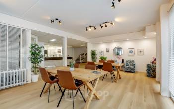 Bright, modern office space at Bruningweg 23 in Arnhem IJsseloord, featuring wooden tables, comfortable chairs, and plants, available for office space rental.