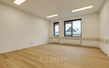 Bright office space with large windows and wooden flooring at Bruningweg 23, Arnhem IJsseloord. Ideal for office space rental, featuring ample natural light and a clean, minimalist design.