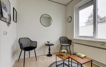 Cozy interior of an office space at Bruningweg 23, Arnhem IJsseloord, featuring modern chairs and a small table, ideal for informal meetings and work. Office space rental opportunity available.