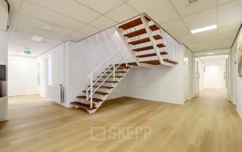 Spacious, unfurnished interior of an office to rent at Bruningweg 23, Arnhem IJsseloord featuring a modern staircase and bright lighting, ideal for creating customized workspaces.
