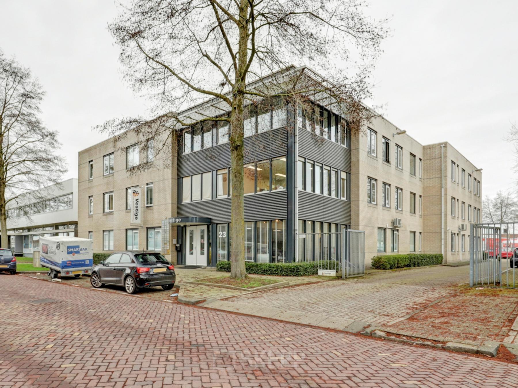 Exterior view of the office building at Bruningweg 23, Arnhem IJsseloord, featuring a modern facade and available parking spaces. Ideal for office space rental in a convenient, professional location.