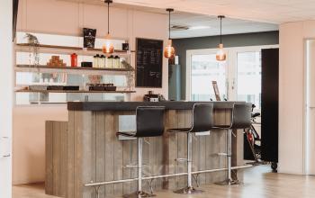 Stylish bar area in an office space at Vlamoven 34, Arnhem IJsseloord, perfect for breaks or informal meetings. Ideal for those looking to rent office space with a unique touch.