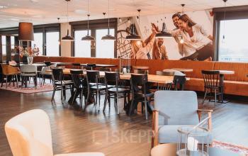 Spacious and well-lit office space with modern furniture at Vlamoven 34, Arnhem IJsseloord. Ideal for companies looking to rent office space with ample seating and contemporary decor.