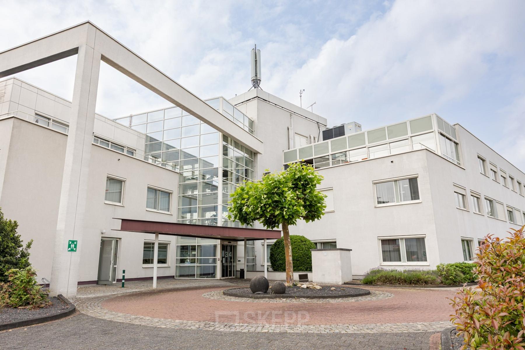 Modern office building at Vlamoven 34, Arnhem IJsseloord, suitable for office space rental, featuring large windows and a sleek exterior design.