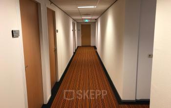 Hallway in an office building at Simon Stevinweg 27, Arnhem Oost, Arnhem with striped carpet and several closed doors.