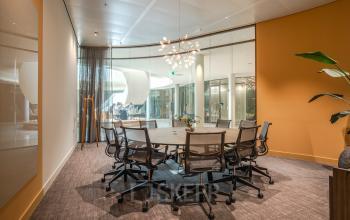 Contemporary conference room in an office to rent at Rijksweg-West 2, Arnhem Zuid, featuring modern furniture and a large round table with chairs.