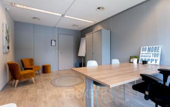 Modern office space rental at Overcingellaan 17, Assen, featuring a minimalistic design with a wooden table, brown chairs, and motivational decor creating an inviting workspace.