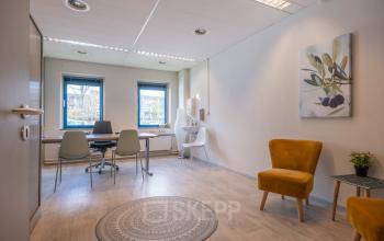 Bright and inviting office to rent at Overcingellaan 17, Assen. The interior features modern furnishings, including a round table with chairs and cozy armchairs, ideal for small meetings or work sessions.