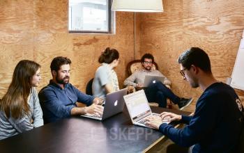 Team members collaborate and work on laptops in an office space rental at Carrer de Vilafranca 7, Barcelona Gràcia.