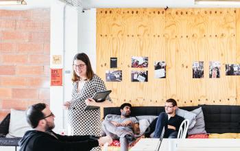 Creative office space for rent in Barcelona Gràcia, featuring a cozy lounge area with people collaborating and discussing projects.