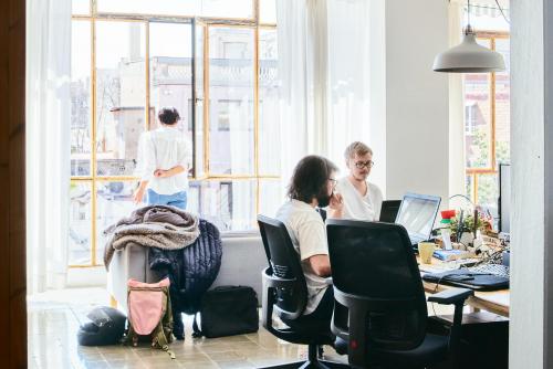 Espacio de oficina en alquiler en Carrer de Vilafranca 7, Barcelona Gràcia, con personas trabajando en escritorios junto a amplias ventanas.
