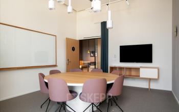 Moderne Bürofläche mieten in Basel St. Alban, Grosspeteranlage 29, mit einem runden Besprechungstisch und eleganter Einrichtung.
