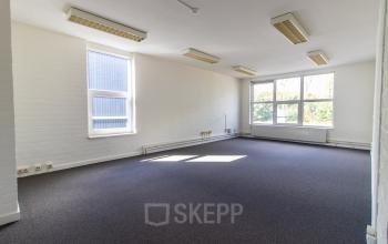Spacious and bright office to rent at Middelweg 25 in Beek Lb, featuring large windows and ample lighting.