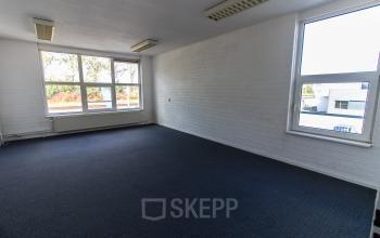 Office space rental at Middelweg 25, Beek Lb, featuring a well-lit, carpeted room with large windows.