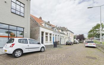 Street view of an office space rental at Bruinevisstraat 32 in Bergen op Zoom with parked cars and neighboring buildings.