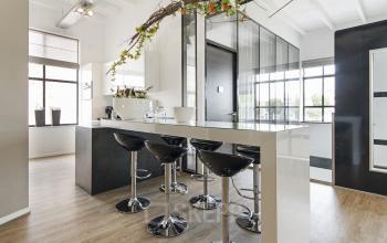 Modern office space rental at Bruinevisstraat 32, Bergen op Zoom, featuring a stylish pantry with bar stools and a vibrant plant arrangement.