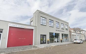 Modern Bergen op Zoom office space rental at Bruinevisstraat 32 with large windows and a bold red entry door.