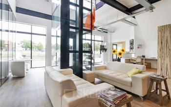 Modern office space rental at Bruinevisstraat 32, Bergen op Zoom featuring a chic lounge area with comfortable seating and large windows.