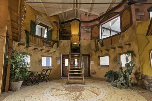 Interior of office at Zuidzijde Haven 39a, Bergen op Zoom featuring a rustic, two-story space with a central staircase, plants, and seating area.