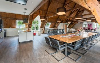 Spacious office at Blokstallen 2B, Bergen op Zoom with wooden beams, modern furnishings, large tables, and ample natural light, ideal for office space rental.