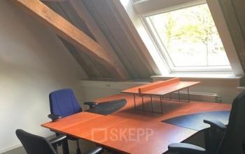 Office space with wooden beams, large windows, and several desks and chairs at Blokstallen 2B, Bergen op Zoom, ideal for office space rental.