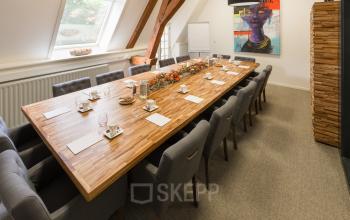A well-appointed conference room at Blokstallen 2B, Bergen op Zoom, perfect for office space rental. Elegant table setting with natural light from skylights.