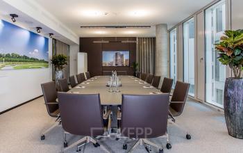 Konferenzraum im Upper West Tower, Kurfürstendamm 11, Berlin Charlottenburg. Moderne büroraum mieten mit langer Tischreihe, Lederstühlen und Pflanzen.